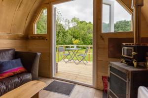 巴特尔Beautiful 1 bed Glamping pod in Battle的带沙发的客厅和通往甲板的门