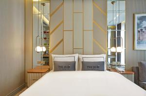 伊斯坦布尔THE HUBİ HOTEL的卧室配有一张带两个枕头的大白色床