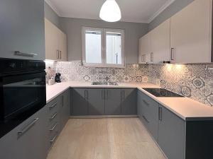 希俄斯Panoramic Apartment的厨房配有白色橱柜和黑色用具