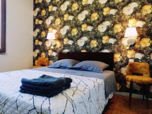 Le HougaLe Logis de la Ferme aux Cerfs的一间卧室配有一张带花卉墙壁的床