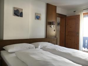 埃尔瓦尔德Landhaus Holzereck的一间卧室配有一张带白色床单的床和一扇窗户。