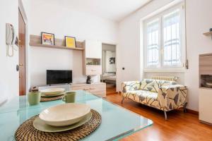 米兰Cozy apartament in Piazza 5 Giornate by Easylife的客厅配有玻璃桌和沙发