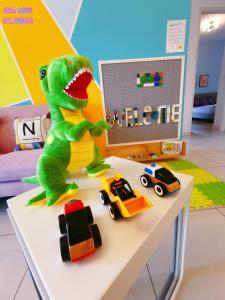 努沙再也Legoland-Happy Wonder Love Suite-Elysia- Max8pax-with Garden-Pool view的玩具车旁边的桌子上坐着玩具恐龙