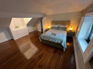 波尔图A Portuguesa Guest House的一间卧室配有一张床,铺有木地板