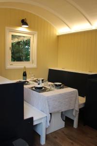 斯托马基特The Tawny Shepherd Hut, Whitehouse Farm的一间用餐室,配有一张桌子和一瓶葡萄酒
