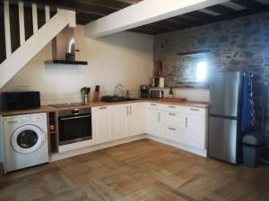 QuettehouMaison Normande proche de la mer et des lieux touristiques的厨房配有白色橱柜、洗衣机和烘干机
