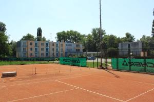 BankaHotel KOREKT的一座带网的网球场和一座建筑