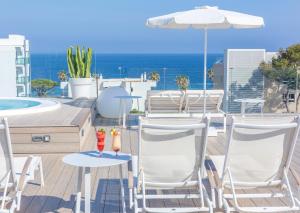 卡拉米洛Marins Playa的一个带椅子和遮阳伞的庭院和一个游泳池