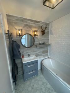 布莱尔高里Alpine Apartments - 2的带浴缸、水槽和镜子的浴室