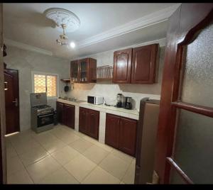 杜阿拉Appartement cosy goldy bonapriso的厨房配有木制橱柜和炉灶烤箱。