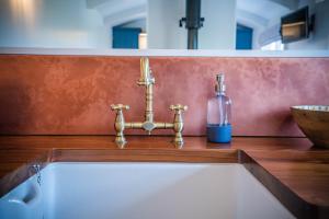 彭里斯Inglewood Shepherd's Huts的一间带水槽的浴室和柜台上的一瓶水