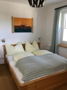 萨尔察赫河畔戈灵Ferienwohnung Neureiter的一间卧室配有带白色枕头的木床