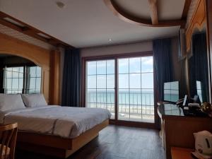 襄阳郡Benikea Hotel Mountain & Ocean Yangyang的一间卧室设有一张床和一个大窗户