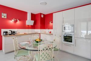 安锡Emergence - Apartment 1 bedroom 2-4 pers Garage and Terrace的厨房设有红色的墙壁和玻璃桌椅
