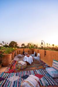 马拉喀什Riad Anya & SPA的庭院配有枕头和桌椅