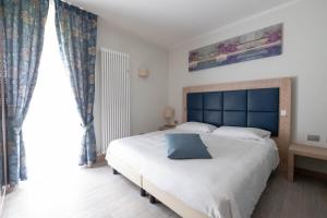 CadareseAlbergo Monte Giove的一间卧室配有一张大床和蓝色床头板