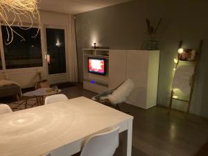 卡兰茨奥赫CallantsDuinzicht, Beachappartement 24的客厅配有电视和桌椅