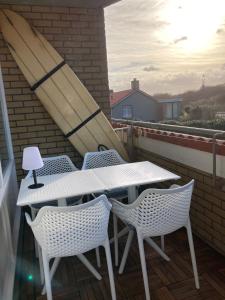 卡兰茨奥赫CallantsDuinzicht, Beachappartement 24的阳台上配有白色的桌椅