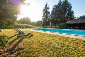 Buzançais薄荷璐堡酒店的坐在游泳池旁的草地上的长凳