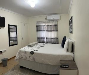 蓬戈拉Ncotshane BnB的卧室配有一张大白色床和窗户