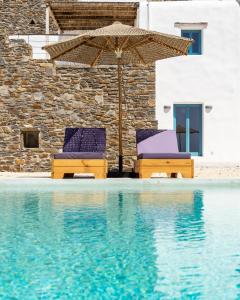 帕罗斯岛Sun House Paros的游泳池旁的两把椅子和一把遮阳伞