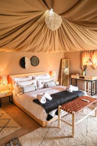 El KariaSelina Agafay Nomad Camp的帐篷内一间卧室,配有一张大床