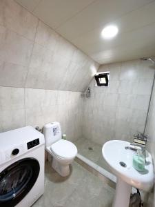 卡兹贝吉Pine Chalet Kazbegi的浴室设有位于卫生间旁的洗衣机和水槽。