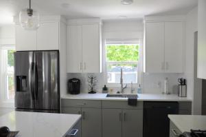 盐湖城Lincoln Street House的厨房配有白色橱柜和不锈钢冰箱