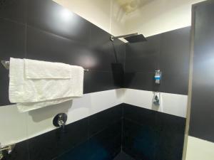 布琼布拉Hotel Hibiscus的黑色和白色的浴室,墙上有一条毛巾