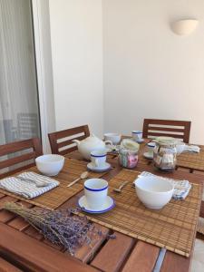 卡拉恩波特Villa Coral的一张木桌,上面放着碗和盘子