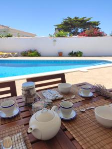 卡拉恩波特Villa Coral的一张桌子,茶具在泳池旁