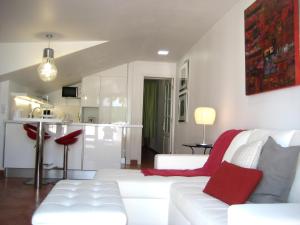马斯帕洛马斯Lacy Golf Apartments的一间带白色沙发的客厅和一间厨房