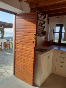 普拉卡米洛斯Drougas' Windmill的厨房设有木墙,旁边是桌子