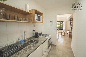 拉里奥哈Casa Adela - Cabañas Resort的厨房配有水槽和炉灶 顶部烤箱