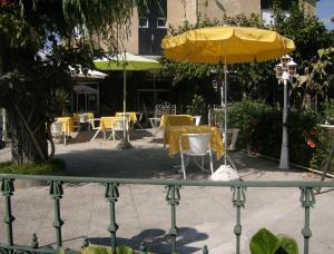 圣托·蒂尔索洋葱酒店 的一张桌子和椅子,配有黄色雨伞