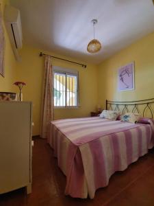 伊斯兰蒂拉Villa de Islantilla的一间卧室配有一张大床和紫色毯子