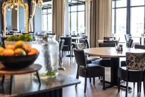 拉尔维克Quality Hotel Grand Larvik的配有桌椅和一碗水果的用餐室