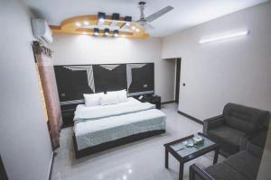卡拉奇Royal Accommodation的一间卧室配有一张床、一把椅子和一张沙发