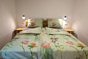 ČrničeApartmaji Tanto Malovše的一间卧室配有一张带花卉床罩的床