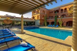 瓜伊马斯Gamma Guaymas Armida Hotel的一个带蓝色躺椅的度假游泳池和一座建筑