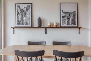 奥尔日河畔于维西Appart'Hôtel Luminous Vue Seine- Paris 15min的一间带木桌和椅子的用餐室