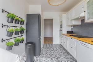 奥尔日河畔于维西Appart'Hôtel Luminous Vue Seine- Paris 15min的厨房配有冰箱和墙上的盆栽植物