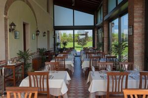 Cavriana阿勒科特德比奇酒店的用餐室设有桌椅和窗户。