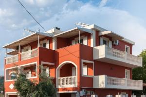 卡拉马孔Avyssos Residents的一座红色的建筑,设有白色的阳台