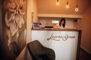 尼什Laguna Green Guest House的坐在房间柜台上的女人