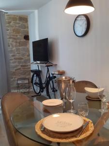 迪南L' atelier du 26的一间设有玻璃桌和时钟的餐厅