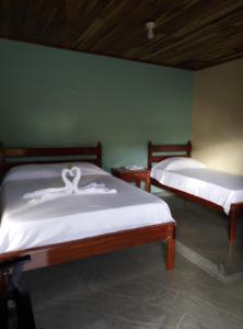 San RafaelCabinas El Pilón Río Celeste的客房内的两张床和白色床单