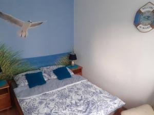 弗瓦迪斯瓦沃沃APARTAMENT LAZUROWY的一间卧室,卧室里配有一张床,鸟儿飞过头顶