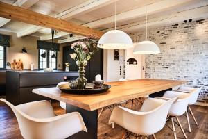 圣彼得奥尔丁MeinNest31的一间带木桌和白色椅子的用餐室