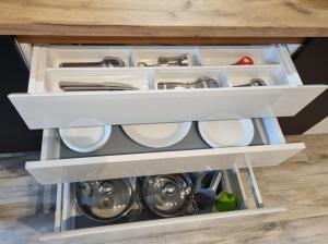 罗兹Apple Apartments - Gdańska PRYWATNE MIEJSCE PARKINGOWE的开放式厨房抽屉,配有餐具和器 ⁇ 